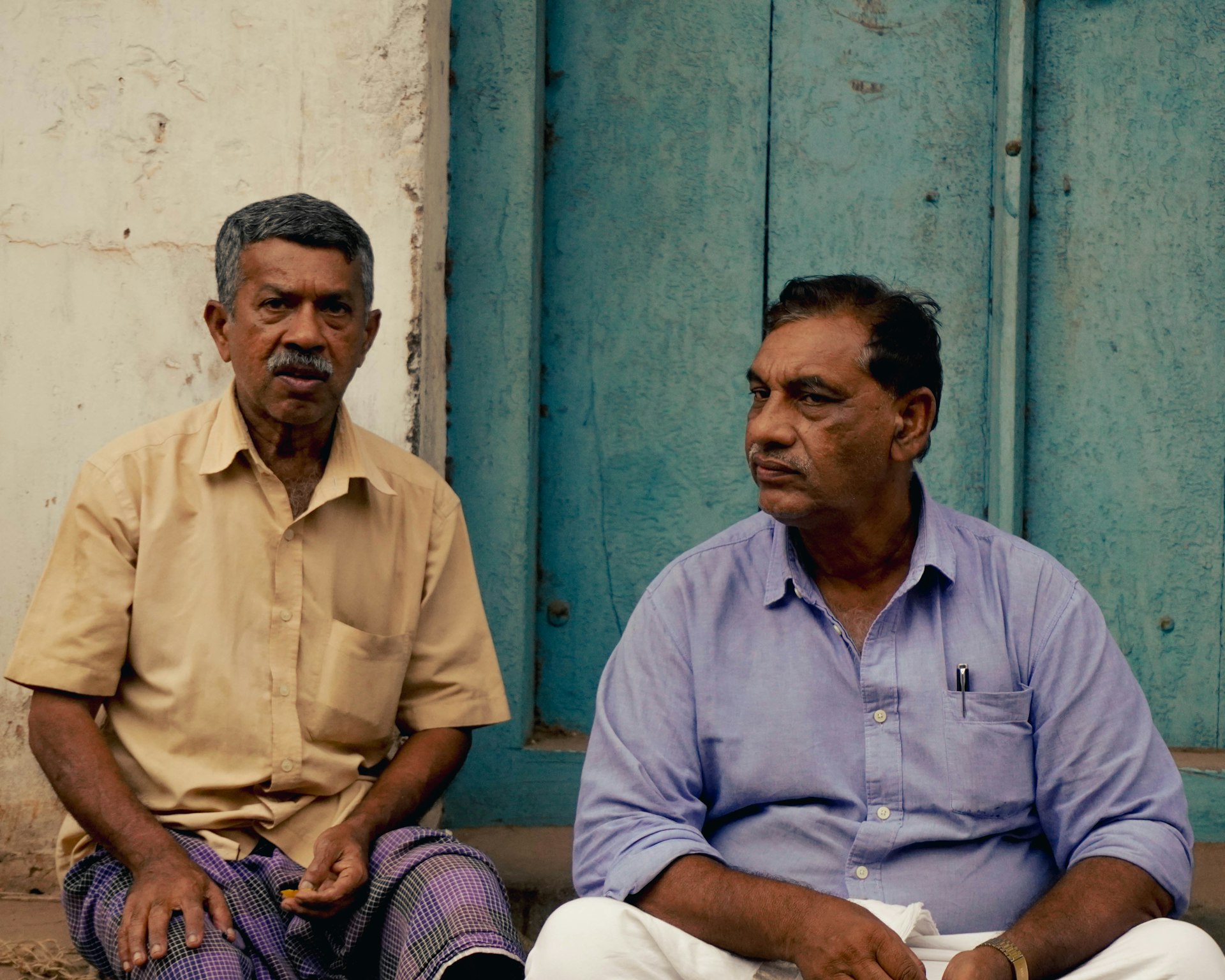 a couple of men sitting next to each other